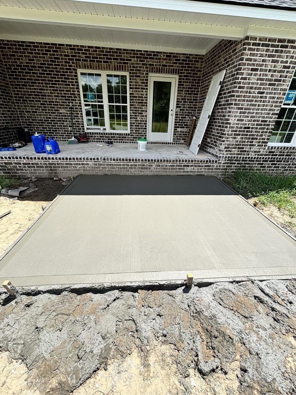 Fresh concrete back patio at a brick house