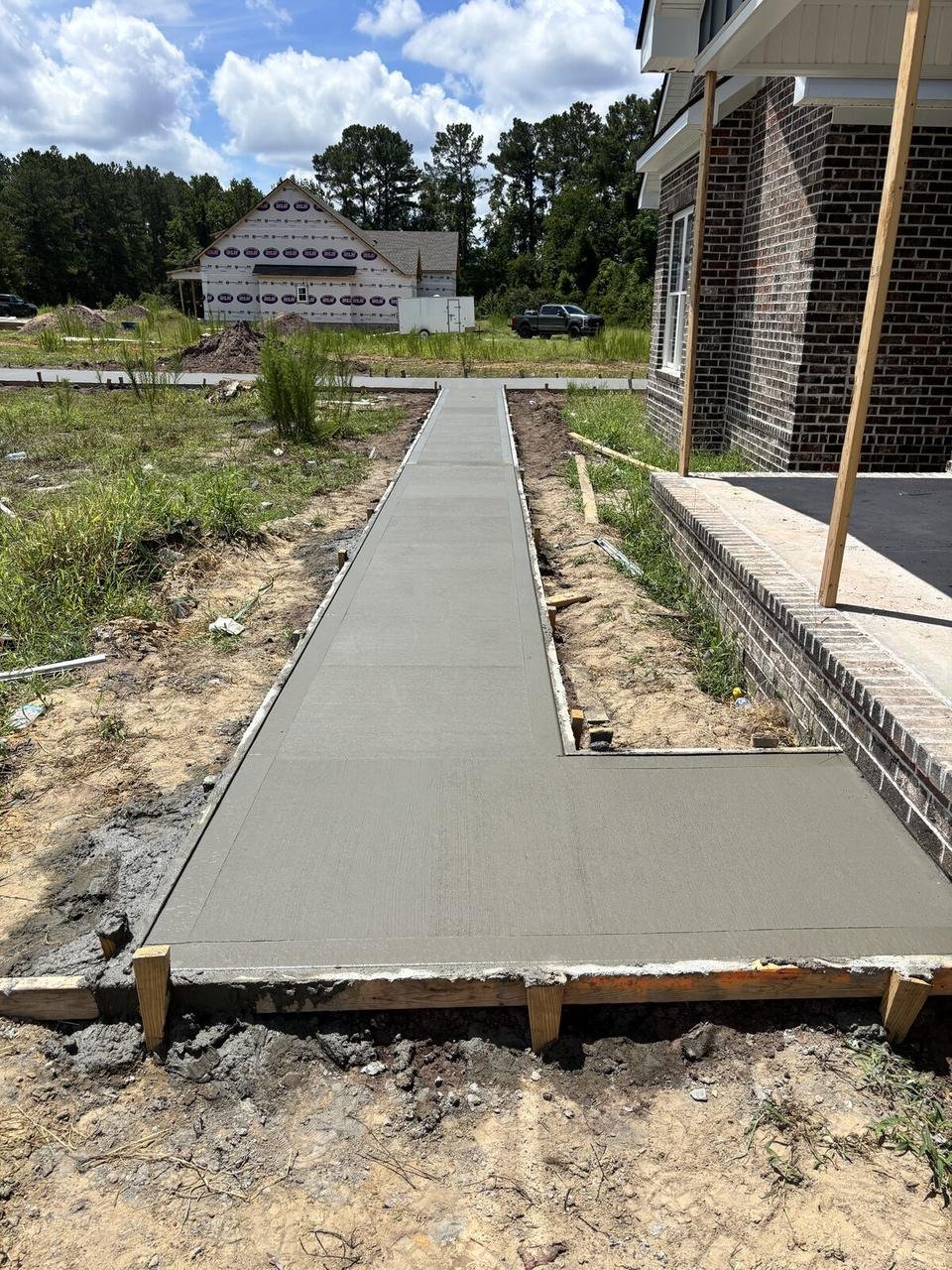 Finished sidewalk next to a new brick home